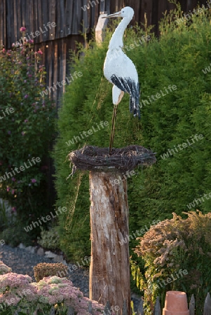 Storch im Nest auf Pfahl mit Spinnennetz im Sonnenlicht, Deko