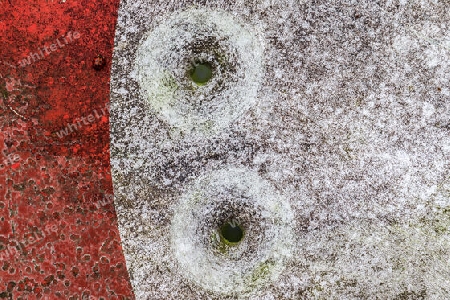 Detailed close up of bullet holes from gun shots in a german traffic sign