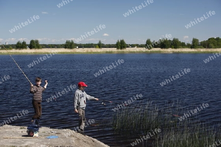 Eine Lagune mit jungen Fischern an der Ostsee bei Jurmala im westen von Riga und im Zentrum von Lettland