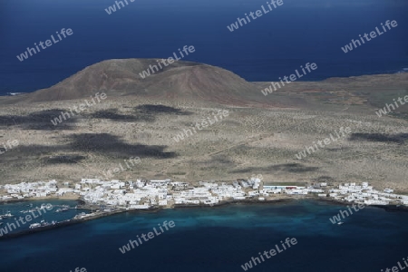 The  Isla Graciosa with the village of Caleta del Sebothe from the Mirador del Rio viewpoint on the Island of Lanzarote on the Canary Islands of Spain in the Atlantic Ocean. on the Island of Lanzarote on the Canary Islands of Spain in the Atlantic Oc