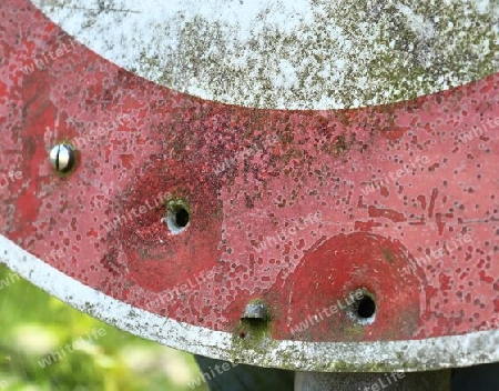 Detailed close up of bullet holes from gun shots in a german traffic sign