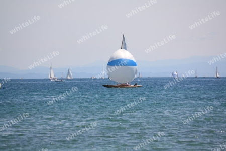 Bodensee mit Segelschiffen und Bergen im Hintergrund