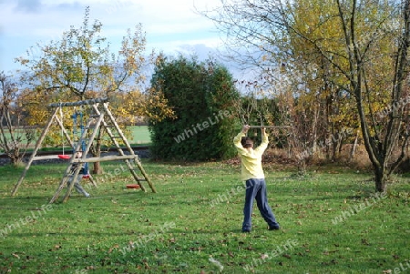 Zwei Buben spielen im herbstlichen Garten