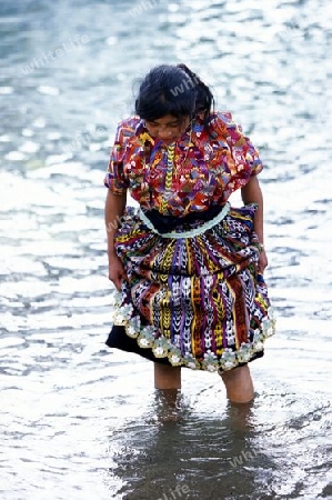 People at the coast of Lake Atitlan mit the Volcanos of Toliman and San Pedro in the back at the Town of Panajachel in Guatemala in central America.   