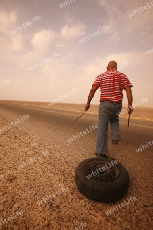 A flat tire on a Taxi on the Desertroad 65 near the Towns Safi and Aqaba in Jordan in the middle east.