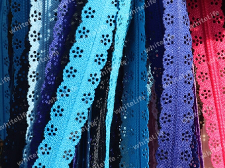 Detailed close up view on samples of cloth and fabrics in different colors found at a fabrics market.