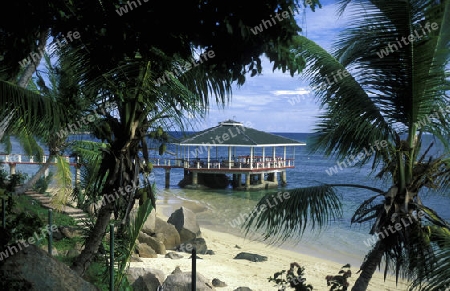 Ein Hotelstrand mit Pavillon bei Sonnenuntergang auf der Insel Praslin auf den Seychellen im Indischen Ozean.