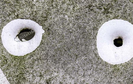 Detailed close up of bullet holes from gun shots in a german traffic sign