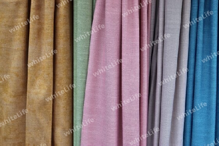 Detailed close up view on samples of cloth and fabrics in different colors found at a fabrics market.