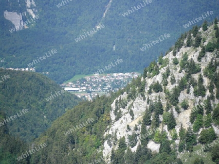 Ein Berg im Vordergrund und ein Ort im Hintergrund