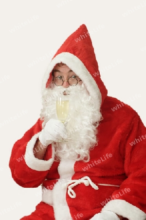 Weihnachtsmann mit einem Glas Sekt. Freigestellt auf weissem Hintergrund.