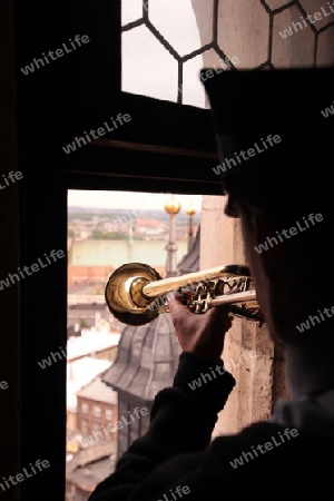 Der Turmblaeser bei einem Trompetensignal auf dem Turm der Marienkirche in der Altstadt von Krakau im sueden von Polen.