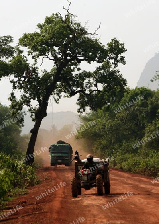 Die Landstrasse 12 beim Dorf Mahaxai Mai von Tham Pa Fa unweit der Stadt Tha Khaek in zentral Laos an der Grenze zu Thailand in Suedostasien.