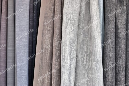 Detailed close up view on samples of cloth and fabrics in different colors found at a fabrics market.