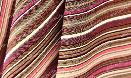 Detailed close up view on samples of cloth and fabrics in different colors found at a fabrics market.