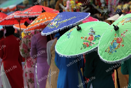 Menschen mit Papierschirmen an der Festparade beim Bun Bang Fai oder Rocket Festival in Yasothon im Isan im Nordosten von Thailand. 