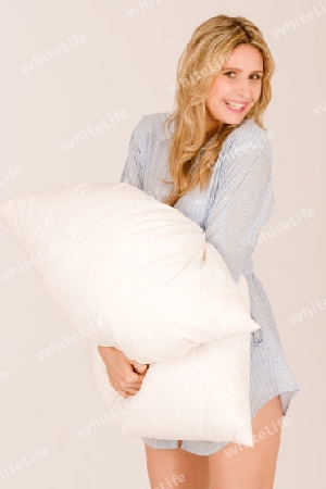 blonde Haaren stehend mit Kissen Kissen. Sie traegt ein Nachthemd und laechelt / blonde hair, standing with pillow cushions. She is wearing a nightgown and smiles