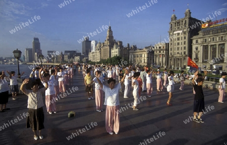 people dancing in the morning on the Bund in front of the skyline of Pudong in the City Shanghai in China.