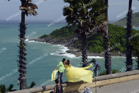 Ein Hochzeitspaar bei einem Fototermin am Aussichtspunkt Kap Promthep bei der Rawai Beach im sueden der Insel Phuket im sueden von Thailand in Suedostasien.