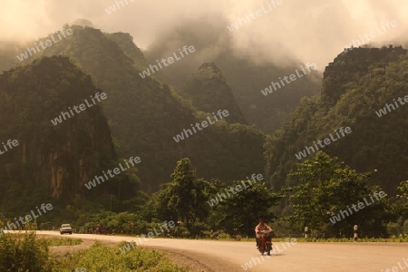 Die Landstrasse 12 beim Dorf Mahaxai Mai von Tham Pa Fa unweit der Stadt Tha Khaek in zentral Laos an der Grenze zu Thailand in Suedostasien.