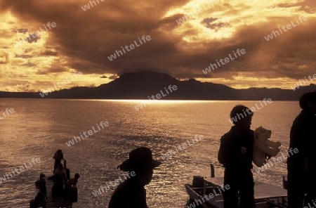 People at the coast of Lake Atitlan mit the Volcanos of Toliman and San Pedro in the back at the Town of Panajachel in Guatemala in central America.   