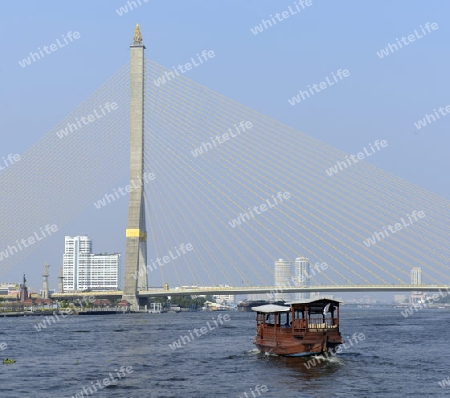 Ein traditionelles Holzboot bei der Bruecke Saphan Phra Ram Vlll auf dem Mae Nam Chao Phraya River in der Hauptstadt Bangkok von Thailand in Suedostasien.