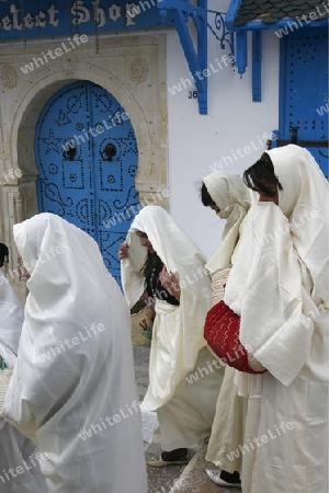 Afrika, Nordafrika, Tunesien, Tunis, Sidi Bou Said
Junge Frauen im traditionellen weissen Schleier in der Altstadt von Sidi Bou Said in der Daemmerung am Mittelmeer und noerdlich der Tunesischen Hauptstadt Tunis. 






