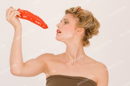 Blonde junge Frau mit Chili im Haar und Paprika / Blonde young woman with hair in chili peppers and Parika