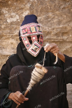 a Beduin women at work to spinning woll in the Temple city of Petra in Jordan in the middle east.