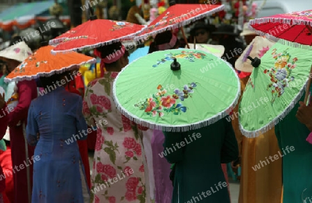 Menschen mit Papierschirmen an der Festparade beim Bun Bang Fai oder Rocket Festival in Yasothon im Isan im Nordosten von Thailand. 