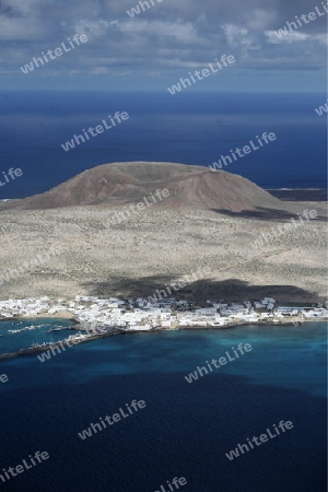 The  Isla Graciosa with the village of Caleta del Sebothe from the Mirador del Rio viewpoint on the Island of Lanzarote on the Canary Islands of Spain in the Atlantic Ocean. on the Island of Lanzarote on the Canary Islands of Spain in the Atlantic Oc