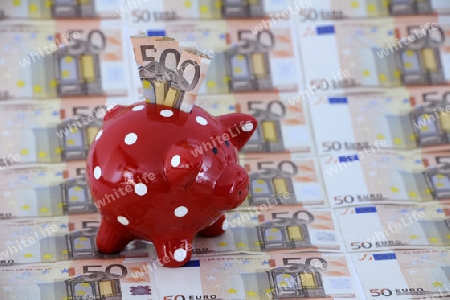 rotes Sparschwein mit weissen Punkten und diversen 50 Euro Banknoten