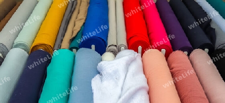 Detailed close up view on samples of cloth and fabrics in different colors found at a fabrics market.