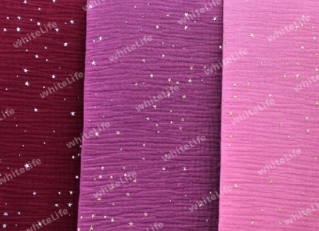 Detailed close up view on samples of cloth and fabrics in different colors found at a fabrics market.