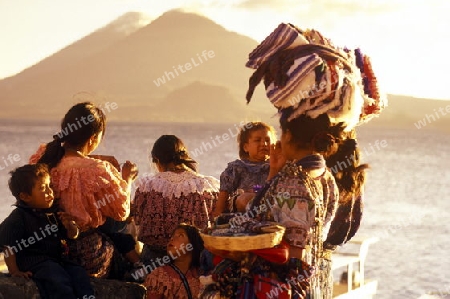 People at the coast of Lake Atitlan mit the Volcanos of Toliman and San Pedro in the back at the Town of Panajachel in Guatemala in central America.   