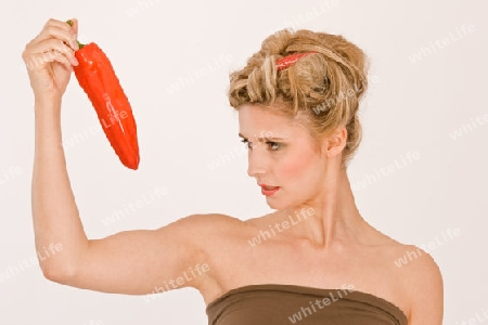 Blonde junge Frau mit Chili im Haar und Paprika / Blonde young woman with hair in chili peppers and Parika