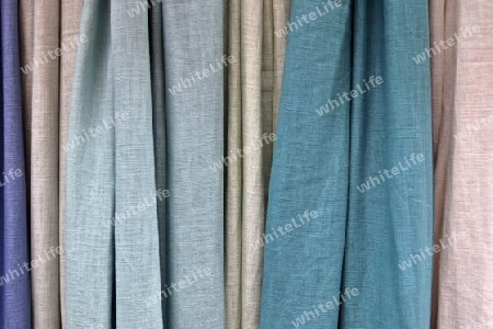 Detailed close up view on samples of cloth and fabrics in different colors found at a fabrics market.