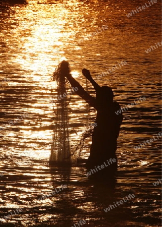 Suedamerika, Karibik, Venezuela, Isla Margarita, Juangriego, Fischmarkt, Fisch, Fischer, Netz, Mann, Abend, Fischernetz auswerfen, Sonnenuntergang, Arbeit, Wirtschaft,  Alltag, Markt am Strand