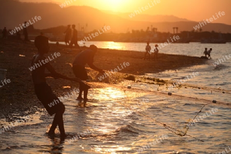 Fischer bei Sonnenunteregang am Stadtstrand von Dili der Hauptstadt von Ost Timor auf der in zwei getrennten Insel Timor in Asien. 