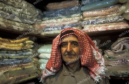 Ein Textilhaendler auf dem Souq oder Markt in der Medina der Altstadt von Aleppo im Norden von Syrien im Nahen Osten. 
