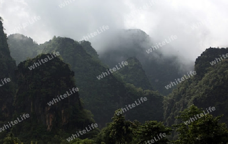 Die Huegellandschaft an der Landstrasse 12 zwischen der Stadt Tha Khaek und dem Dorf Mahaxai Mai in zentral Laos an der Grenze zu Thailand in Suedostasien.