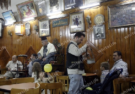 Der Geschichtenerzaehler Abu Shady im Cafe An Nafura im Souq oder Markt in der Altstadt und Hauptstadt von Syrien und Grossstadt von Damaskus in der uebersicht, Syrien 