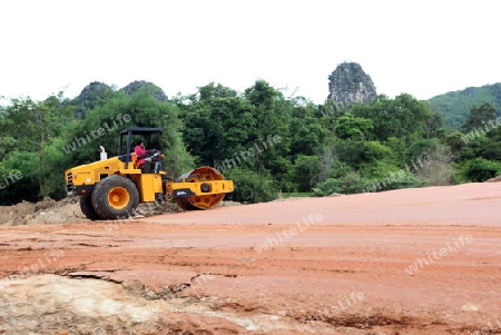 Ein neue Strasse wird gebaut, dies zur Buddha Hoehle oder Buddha Cave (Innen ist Fotografieren verboten) von Tham Pa Fa unweit der Stadt Tha Khaek in zentral Laos an der Grenze zu Thailand in Suedostasien.