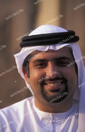 a portrait of a Arab men in the souq or Market in the old town in the city of Dubai in the Arab Emirates in the Gulf of Arabia.