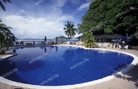 Ein Hotelstrand mit Pavillon bei Sonnenuntergang auf der Insel Praslin auf den Seychellen im Indischen Ozean.