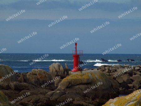 rote Markierung der Hafeneinfahrt mit Atlantik im Hintergrund