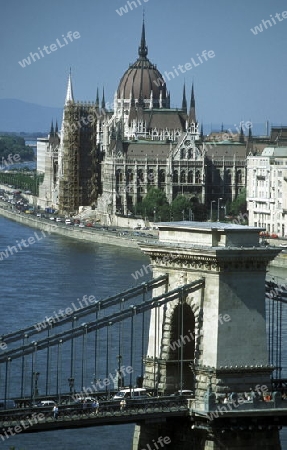 Die Kettenbruecke ueber der Donau und das Parlament in der Hauptstadt von Ungarn in Osteuropa..