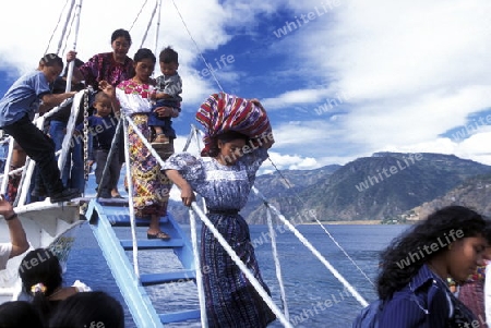 People at the coast of Lake Atitlan mit the Volcanos of Toliman and San Pedro in the back at the Town of Panajachel in Guatemala in central America.   