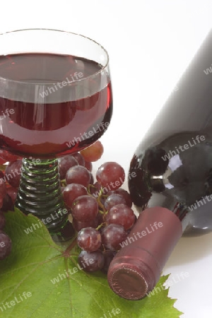 Rotwein mit roten Trauben auf hellem Hintergrund