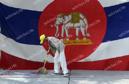 Ein Mann reinigt ein podium mit einer Thailaendischen Flagge im Stadtteil Banglangphu in der Hauptstadt Bangkok von Thailand in Suedostasien.